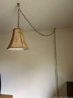 overall view of chain-hung beige fabric pendant light mounted to ceiling