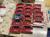Fifteen Holiday Joy four-pack boxes of C9 bulbs in assorted colors on table