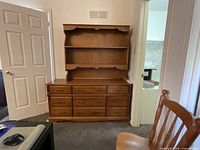 Front view of dresser with hutch showing nine drawers and open shelving