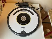 iRobot Roomba 665 vacuum with dock and cord on tabletop