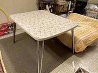 Full view of rectangular starburst laminate table with chrome legs