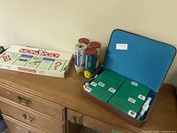 Overall lot showing Monopoly box, open Mahjong case with contents and three tennis ball cans