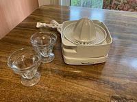 Moulinex Model 680 citrus juicer with power cord, juicing cone and two glass cups displayed on tabletop