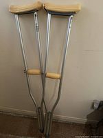 Full view of both crutches leaning against wall