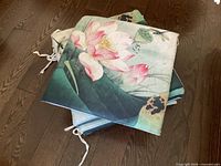 Stacked floral lotus print chair cushions showing design, ties and fabric texture