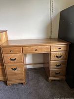 Front view of light brown desk with seven drawers