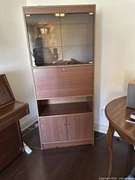 Full view of closed hutch showing glass upper section, drop-down desk, lower cabinet