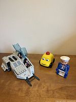 All items grouped: G.I. Joe vehicle with two figures seated, Fisher-Price car, Playmobil sailor