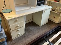 Front view of cream laminate desk showing drawers and cabinet
