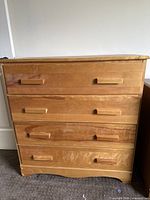Front view of solid wood 4-drawer dresser showing drawer fronts and pulls
