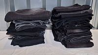 Two stacks of folded dark women’s jeans