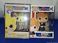 Front view of both boxed Funko Pop figures in protectors