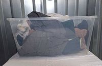 Clear tote displaying five fleece jackets, bin not included