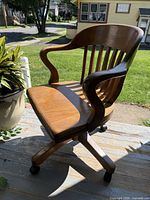 Front angled view showing curved arms, seat, casters