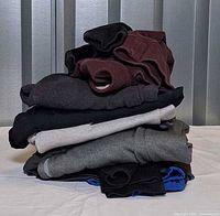 Stack of the eight folded athletic tops showing colour variety
