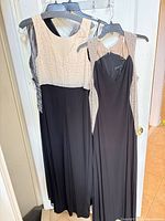 Two sleeveless beaded evening gowns hanging