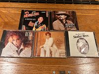All five country CDs arranged on wooden surface showing front covers