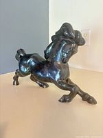 Left-side view of the ceramic horse showing iridescent glaze and full body stance