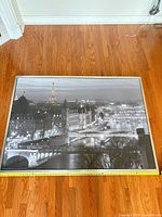 Full view of framed Paris cityscape print lying on floor