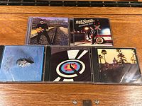 All five CDs arranged on wooden surface showing album artwork