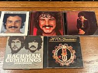 All five CD cases laid out showing front cover artwork