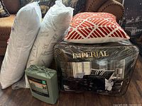 Group shot showing comforter package, sheet set bag, two packaged king pillows, decorative throw pillow