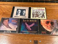 All five CDs laid out on a wooden surface showing front artwork