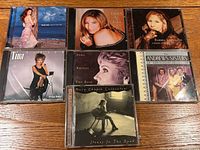 All seven CD albums arranged on wood surface showing front artwork
