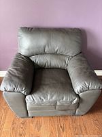 Single oversized black faux leather armchair front view