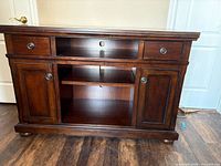 Front view showing drawers, open shelf, and cabinet doors closed