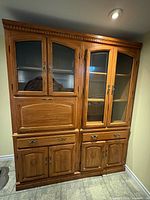 Full view of wood china cabinet showing glass display doors, drawers, lower cabinets