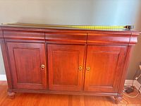 Front view of sideboard showing overall design, drawers, doors, hardware, bun feet