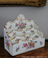 Front view of Dresden porcelain letter rack showing three compartments, floral decoration and gilt trim