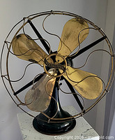 Front view of Westinghouse brass blade fan showing full cage and base
