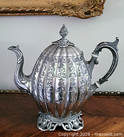 Front view showing engraved fluted body, spout, handle, foot
