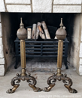Full view of both brass andirons in fireplace setting