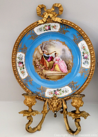 Full view of porcelain plaque wall sconce with gilt bronze arms