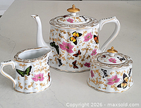 Front view of teapot, sugar bowl and creamer showing pattern and condition