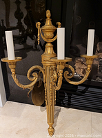 Front view of gilt metal 3-light wall sconce