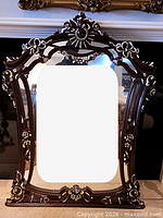 Front view of ornate wooden mirror showing full frame and carvings