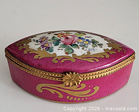 Front angled view of pink Limoges trinket box showing clasp and floral lid