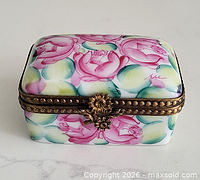 Front three-quarter view showing floral pattern and brass clasp