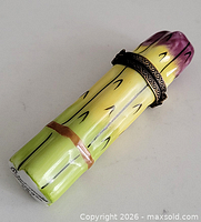 Full view of porcelain asparagus trinket box showing painted colors and brass mount
