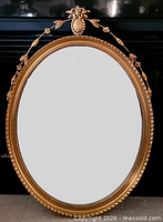 Front view of oval giltwood mirror showing full frame and glass