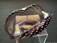 Angled view showing amethyst controlled bubble art glass dish on stand