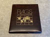 Closed brown faux-leather album front cover with gold title and map design