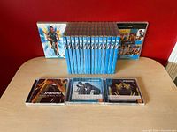 DVD and CD collection displayed: row of sixteen blue Les Mills RPM DVDs, three Spinning CDs in jewel cases, additional visible RPM covers