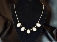 Front view of necklace on display form showing five teardrop charms and chain