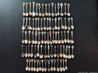 Full layout of 80+ souvenir and crest spoons on flat surface