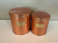 Both copper-tone canisters with lids on